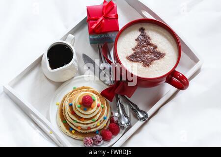 Natale la colazione su un vassoio di frittelle e caffè con cioccolato spolverata Foto Stock