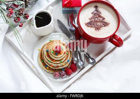 Natale la colazione su un vassoio di frittelle e caffè con cioccolato spolverata Foto Stock