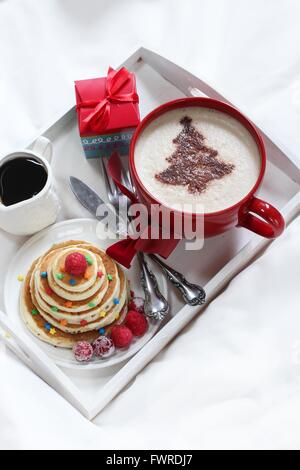 Natale la colazione su un vassoio di frittelle e caffè con cioccolato spolverata Foto Stock