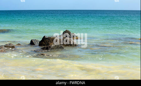 Calma Oceano Indiano che lambisce le rocce di granito a groyne Bunbury Western Australia su una soleggiata mattina d'estate. Foto Stock