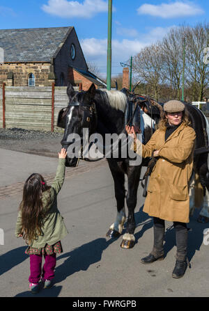 Ragazza giovane petting un cavallo al Black Country Living Museum, Dudley, West Midlands, Regno Unito Foto Stock