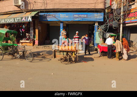 Scena di strada nella parte vecchia della città di Amritsar nel Punjab, India con le persone che visitano i negozi e venditori ambulanti. Foto Stock