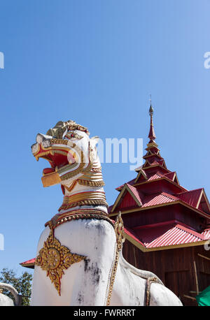 Stucco santo lion nel buddismo nel cielo blu sullo sfondo. Luogo di culto in Thailandia. Foto Stock