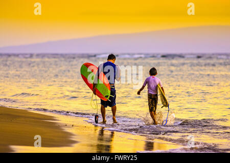 Camminando sulla spiaggia con tavole da surf in Lahaina, Maui Foto Stock