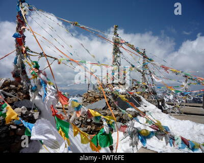 Preghiera tibetano bandiere sulla cima della montagna alla neve Shika Mountain Scenic Area, Shangri-La, Cina Foto Stock