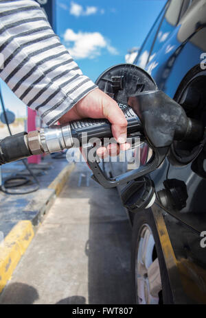 Uomo di pompaggio del carburante benzina in auto alla stazione di gas Foto Stock