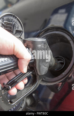Uomo di pompaggio del carburante benzina in auto alla stazione di gas Foto Stock