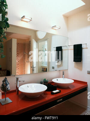 Due lavabo in rosso di piano di lavoro in una moderna stanza da bagno Foto Stock