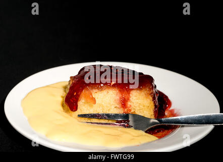 Inceppamento budino di spugna con crema pasticcera - studio shot con uno sfondo nero Foto Stock