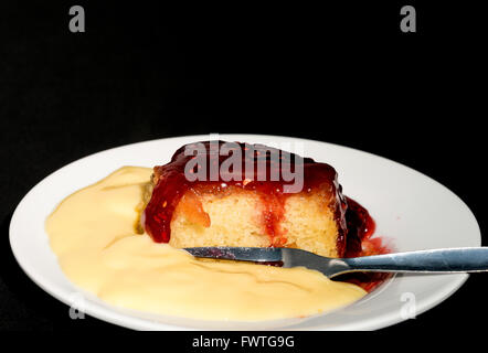 Inceppamento budino di spugna con crema pasticcera - studio shot con uno sfondo nero Foto Stock