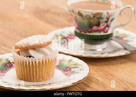 Una tortina di fantasia con una tazza di tè serviti in un antico ornati in tazza e piattino - studio shot Foto Stock