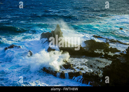 Onde che si infrangono sulla lava formazioni rocciose nell'Oceano Hawaii Maui Foto Stock