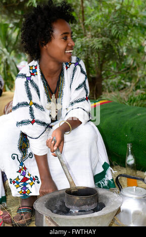 Una giovane donna etiope preparare una tradizionale tazza di caffè etiope. Foto Stock