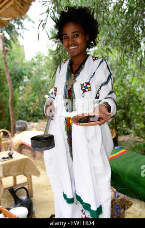 Una giovane donna etiope preparare una tradizionale tazza di caffè. Foto Stock