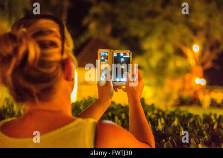 Le donne che prendono un telefono cellulare fotografia di un luau Hawaiiano a Maui Foto Stock