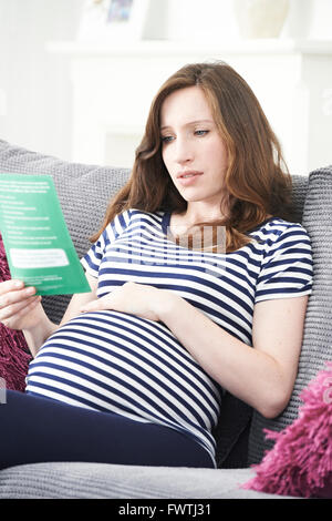 In questione Donna Incinta foglietto di lettura con una consulenza medica Foto Stock