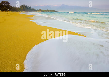 Lavaggio onde sulla spiaggia al tramonto a Baldwin Park, Maui Foto Stock