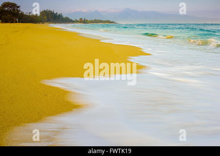 Lavaggio onde sulla spiaggia al tramonto a Baldwin Park, Maui Foto Stock