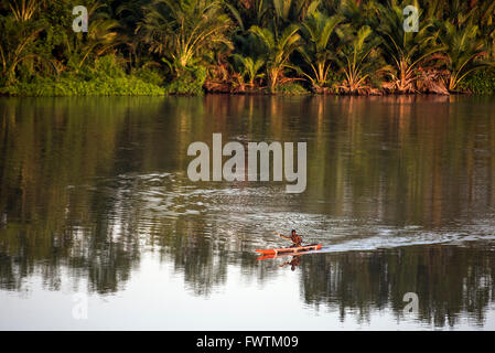 Uomo locale per sguazzare in canoa sul fiume Sepik, Papua Nuova Guinea Foto Stock