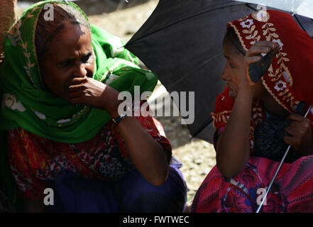 Donne Oromo sotto l'ombrello coloratissimo mercato settimanale bati, Etiopia. Foto Stock