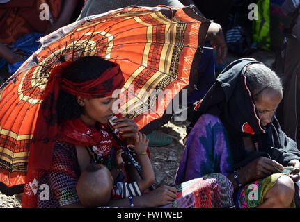 Donne Oromo sotto l'ombrello coloratissimo mercato settimanale bati, Etiopia. Foto Stock