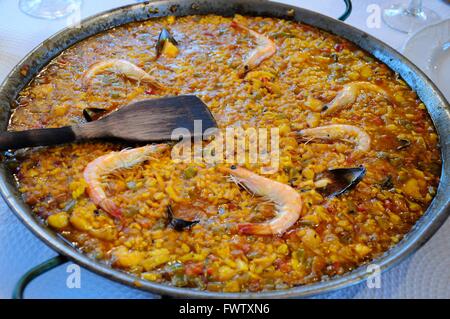 Finito di frutti di mare paella di pesce con una spatola in legno per servire Andalusia Spagna Foto Stock