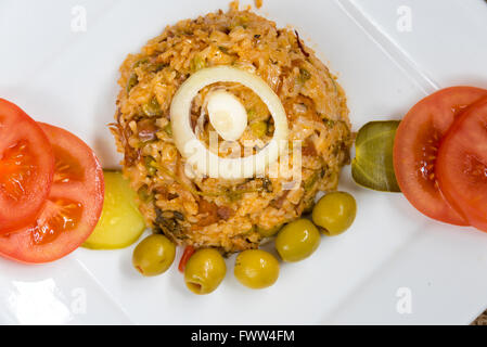 Cucina Cubana tradizionale creola riso giallo guarnito con olive, cipolle, pomodori e pickels. Foto Stock