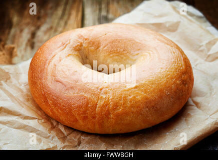 Bagel freschi nel sacchetto di carta sul tavolo in legno Foto Stock