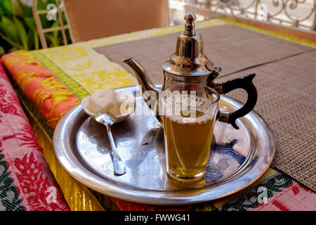 Un bicchiere di tradizionale tè alla menta servito in un bicchiere in una caffetteria nella medina - Marrakech, Marocco, Africa del Nord Foto Stock