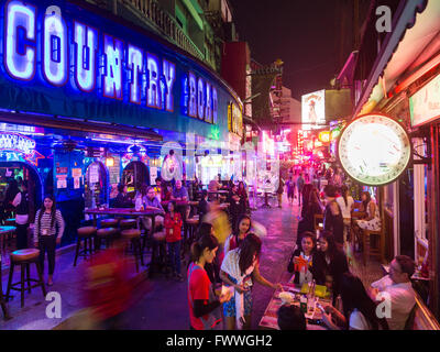 Country Road Music Pub nightly scene di strada nel quartiere a luci rosse con molti bar, Asoke, Sukhumvit Bangkok, Thailandia Foto Stock