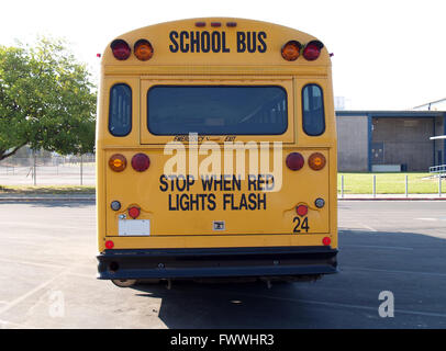 Retro di autobus gialli parcheggiati sulla scuola Foto Stock
