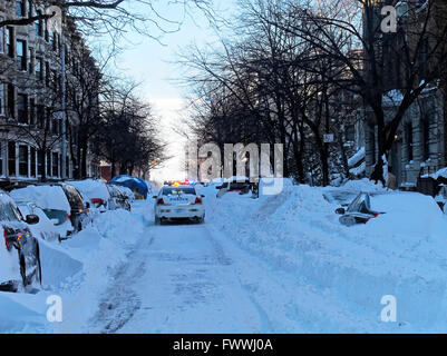Incrociatore della polizia guida attraverso strade coperte di neve strade dopo una tempesta di neve a Brooklyn, New York. Foto Stock