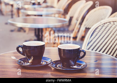 Due tazze di cioccolata calda o un caffè cappuccino sul tavolo in cafe, vicino, in stile vintage Foto Stock