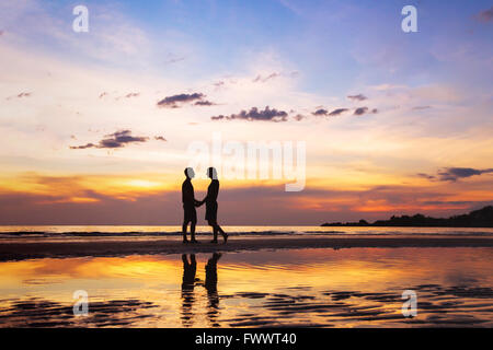 Silhouette di affettuosa giovane sulla spiaggia al tramonto, amore concetto, uomo e donna, bello sfondo Foto Stock