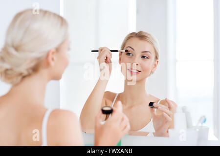 Donna con il trucco pennello e eyeshade al bagno Foto Stock