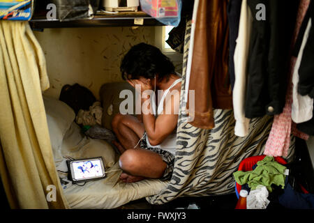 Il Qatar Doha, complesso industriale al di fuori della città, alloggiamento camp per il lavoratore migrante , sei lavoratore filippino condividono un 10 mq di camera, lavoratore Noel comunica da Samsung tablet con la sua famiglia a Manila Foto Stock