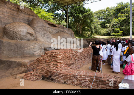 Sri Lanka, Polonnaruwa, Gal Vihara visitatori, guardando il Buddha reclinato, nel parinirvana pongono giacente sul lato destro Foto Stock