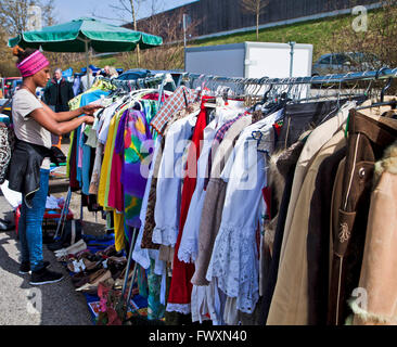 Eching, Germania - ragazza razza mista cerca canzoni di stoffa al mercato delle pulci all'aperto Foto Stock