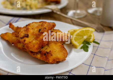 Tradizionale ceca Schnitzel con patate e insalata di verdure su tavola di legno Foto Stock