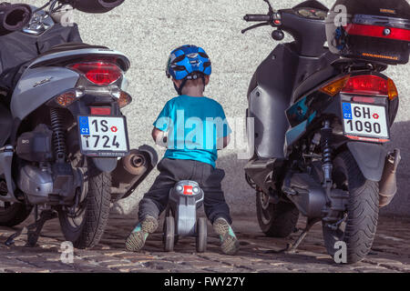 Parcheggio per bambini piccoli per il divertimento in moto, bicicletta per bambini, bambini in bicicletta parcheggiati all'aperto da soli Foto Stock