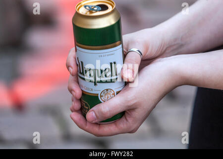 La donna è in possesso di una lattina di birra ceca Pilsner Urquell Foto Stock