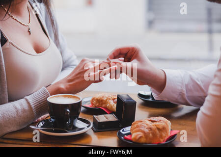 Anello di fidanzamento, proposta in cafe, vicino da mani di uomo e donna Foto Stock