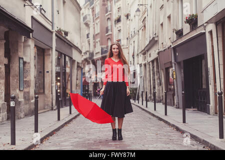 Bella donna, Ritratto di ragazza con ombrello rosso permanente sulla strada di Parigi Foto Stock
