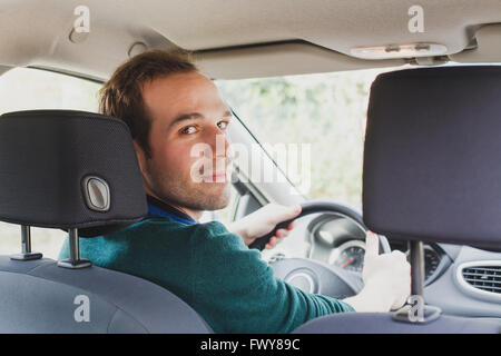 Ritratto di conducente in auto o taxi, giovane uomo caucasico Foto Stock