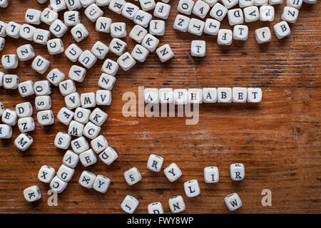 Concetto di alfabeto, la parola scritta con lettere in legno, bianco inglese il testo su sfondo scuro, ABC Foto Stock