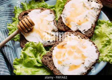 Sandwich di pane di segale, formaggio a pasta morbida, insalata fresca Foto Stock