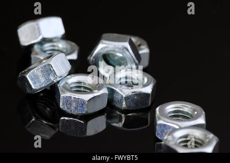 Metallo viti femmina con la riflessione su sfondo nero. Foto Stock