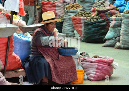 Una donna che stacca le patate in un aprire il mercato degli agricoltori in urubamba Perù. Foto Stock