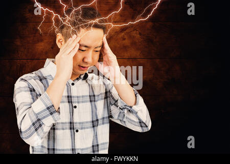 Immagine composita di uomo asiatico ottenendo un mal di testa Foto Stock