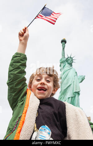 6 anno vecchio ragazzo in piedi di fronte alla statua della Libertà, New York Liberty Island, New York, Stati Uniti d'America. Foto Stock